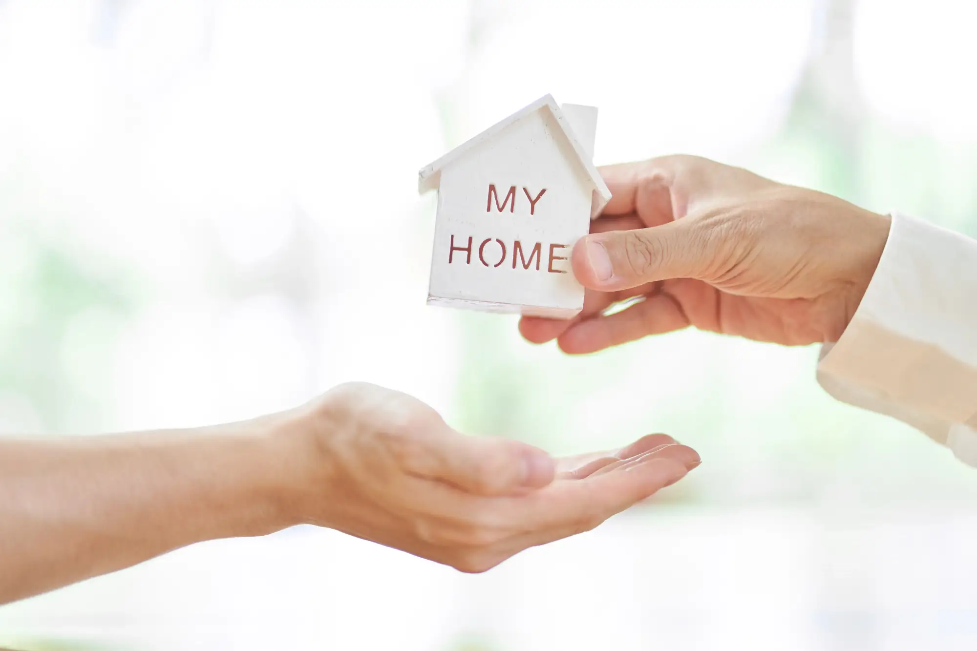 人が手で家を渡す様子